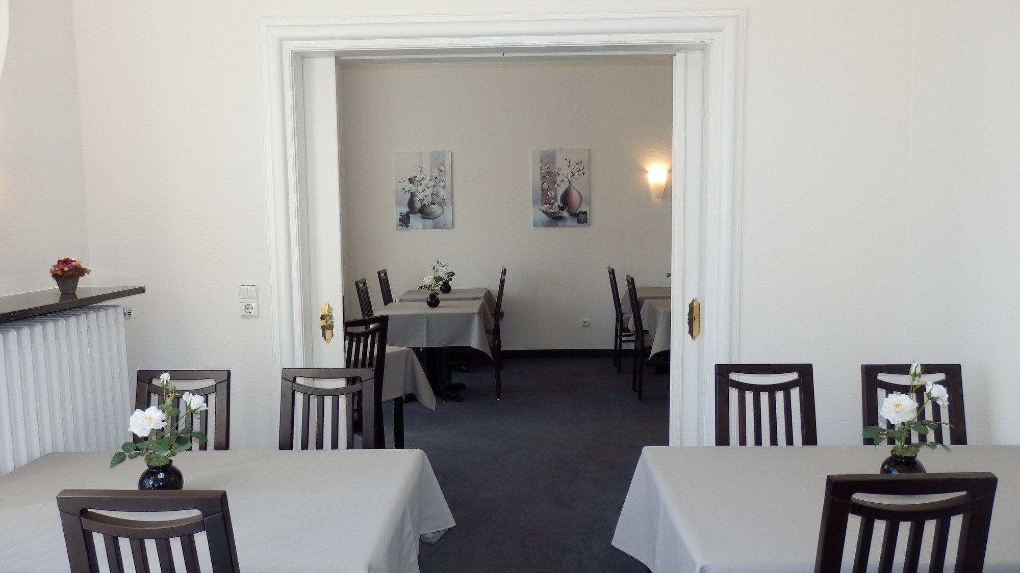 Frühstücksraum Hotel Bellevue Hameln gemütlich eingerichtet mit Tischen und Stühlen